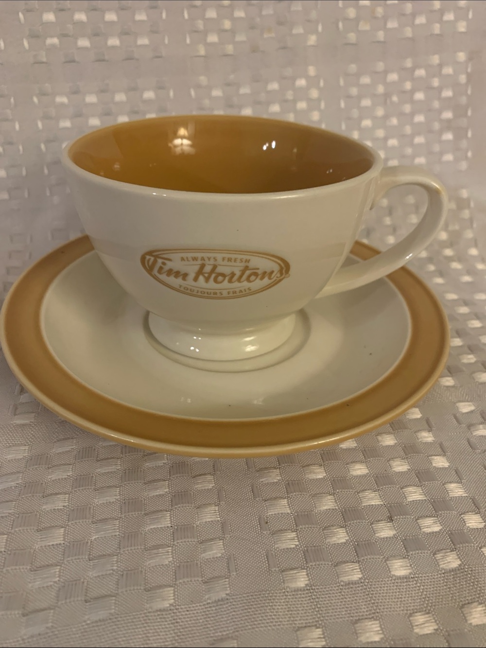 Tim Hortons ceramic teacup and saucer set, cream and gold.